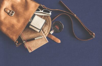 brown leather crossbody bag with white framed sunglasses