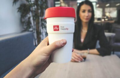 person holding white and red live happilly cup