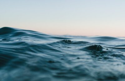 body of water under blue and white skies