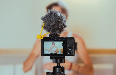 shallow focus photo of a video camera recording an elderly woman
